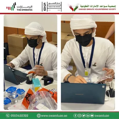 Two volunteers registering participants on laptops